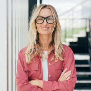 Testimonial Frau mit langen blonden haaren, hat die Arme verschränkt und lächelt in die Kamera